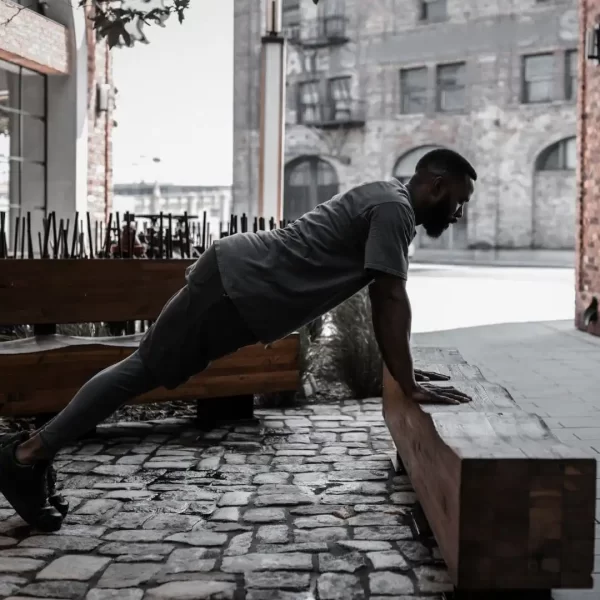 Hombre entrenando al aire libre con su propio peso corporal, demostrando fuerza, equilibrio y disciplina gracias al programa calistenia de cero a fuerte